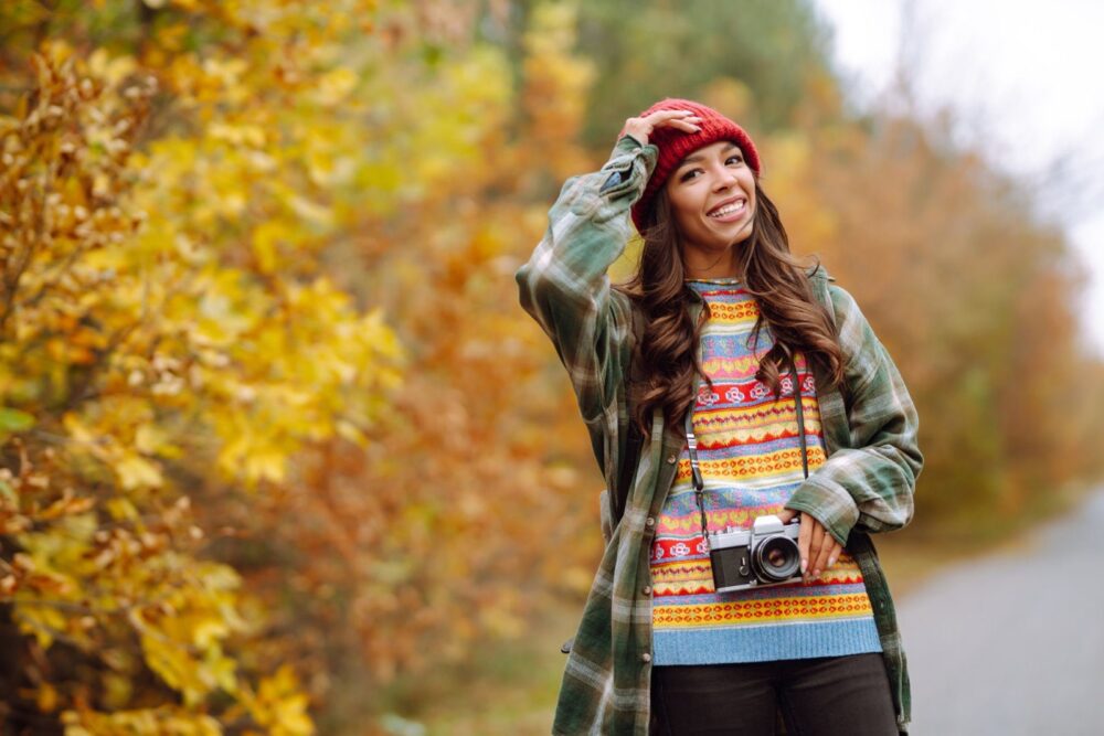 Όμορφη νεαρή γυναίκα φωτογραφίζεται με ρετρό κάμερα. Ξεκούραση, χαλάρωση, ταξίδι, τρόπος ζωής.